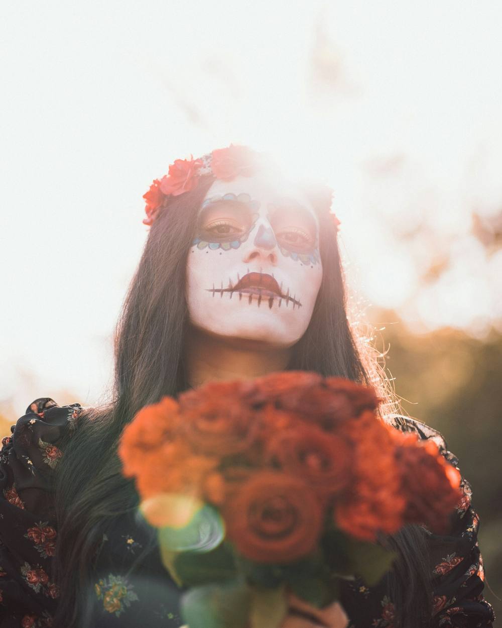 A guest in catrina face paint at golden hour