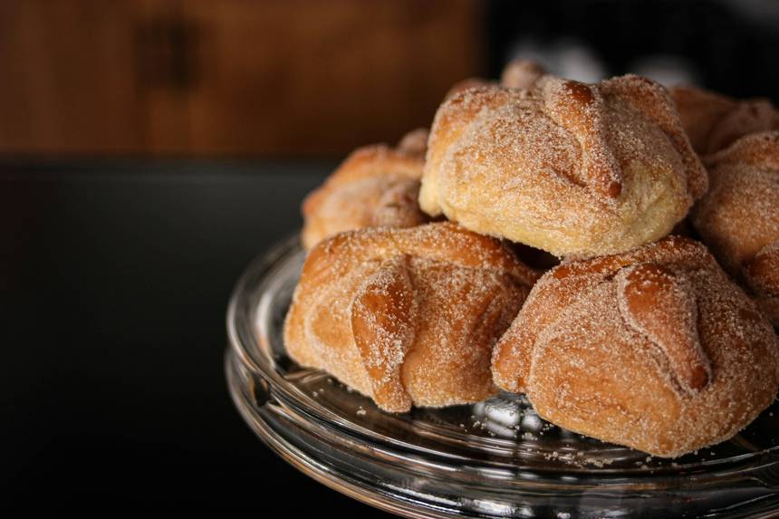 Pan de muerto dusted with sugar on a stand