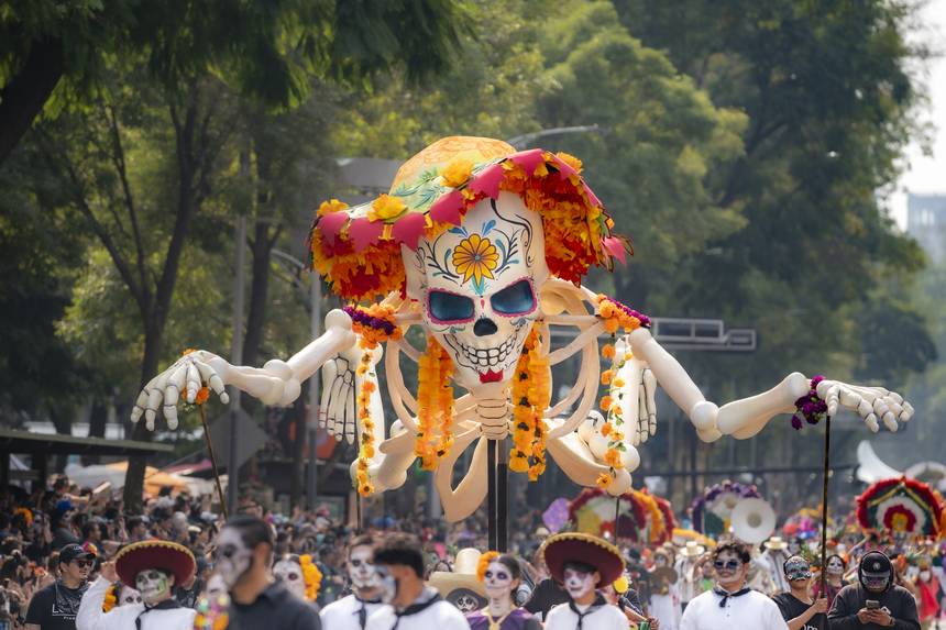 A giant catrina and costumed dancers in the Day of the Dead parade on Paseo de la Reforma