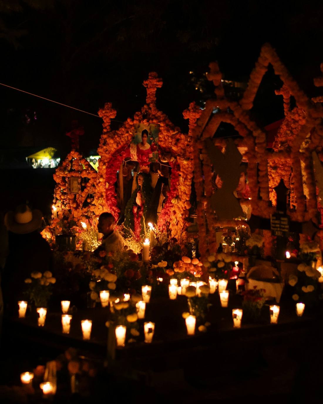 A candlelit ofrenda glowing in the dark